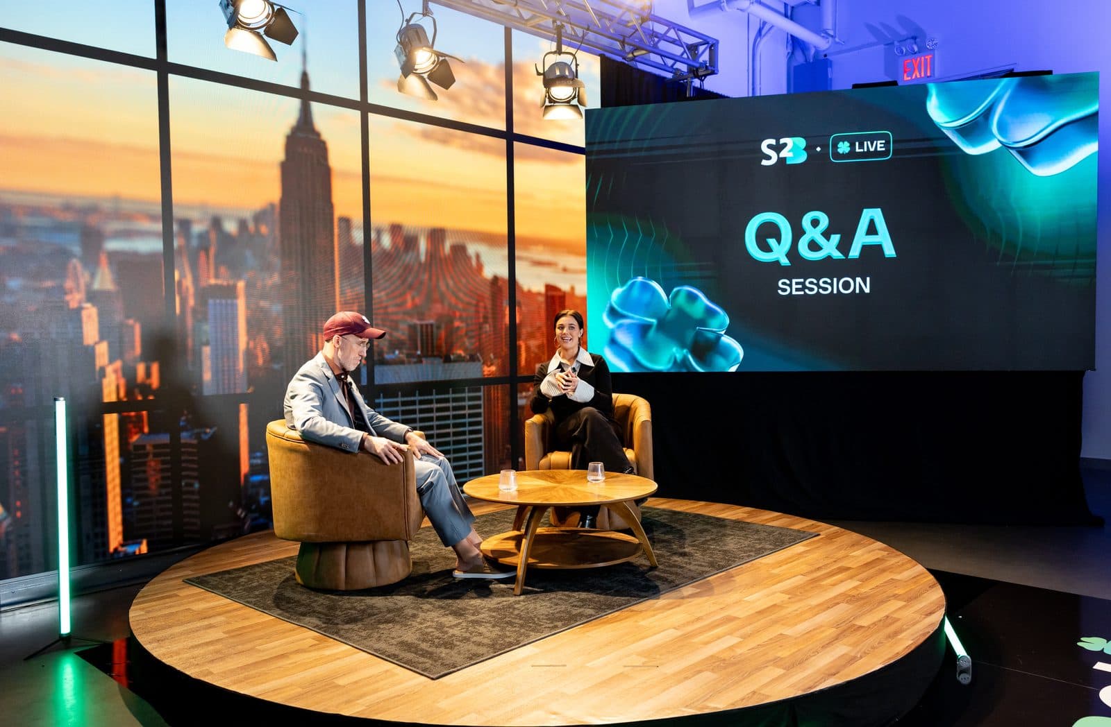 A question and answer session in progress on the AVP.Live corporate set, two speakers on a round stage in front of a Manhattan skyline LED wall